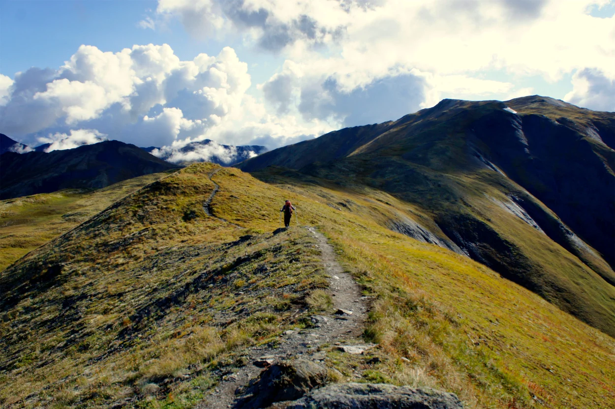 Person hiking along mountain ridge.