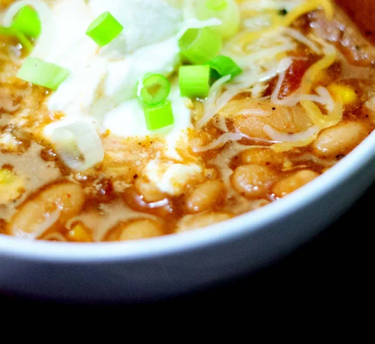 Display of instant pot white bean chili topped with cheese and sour cream
