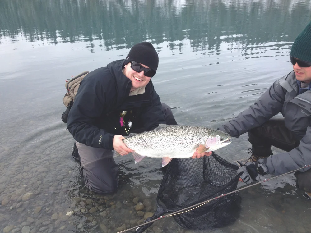 Two men displaying a caught rainbow trout