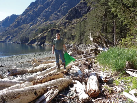 Dan Walker picking trash off the beach.