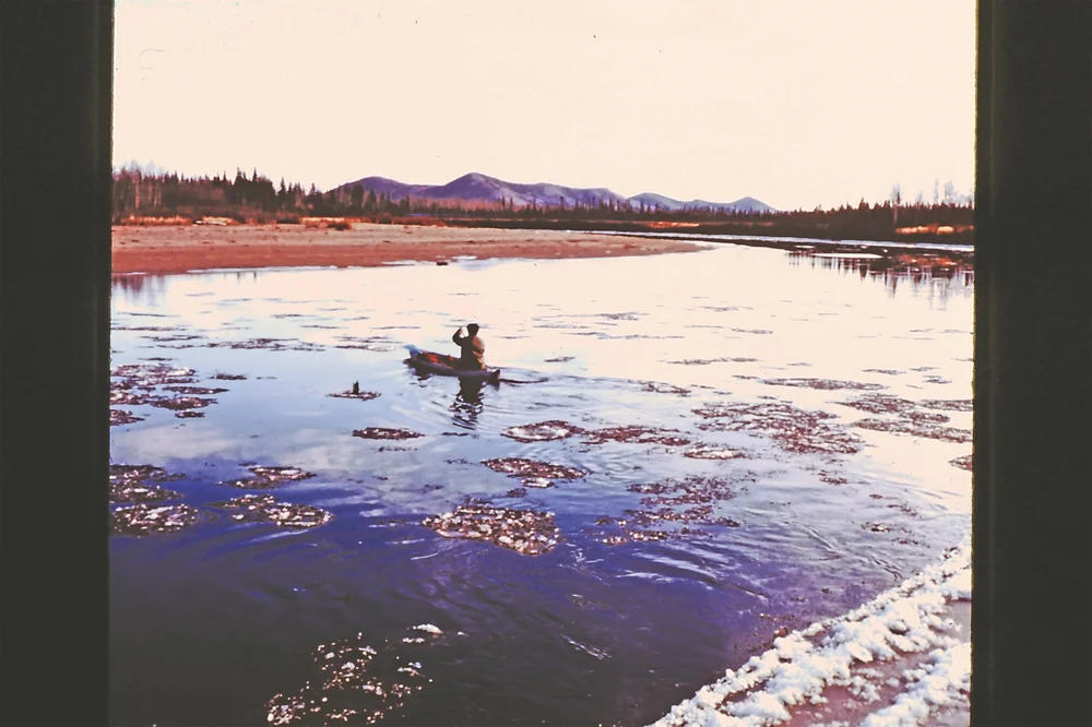 Person traversing river in canoe