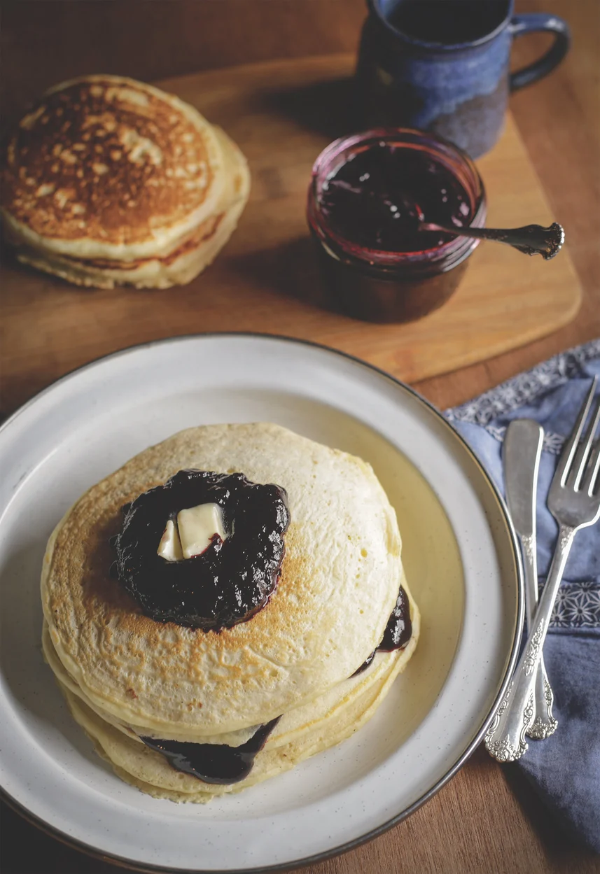 Stack of pancakes with blueberry sauce.