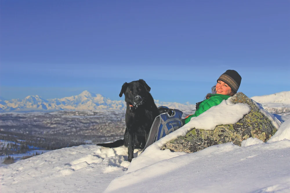 Bonnie and her dog, Howie, relaxing in the snow during a hike